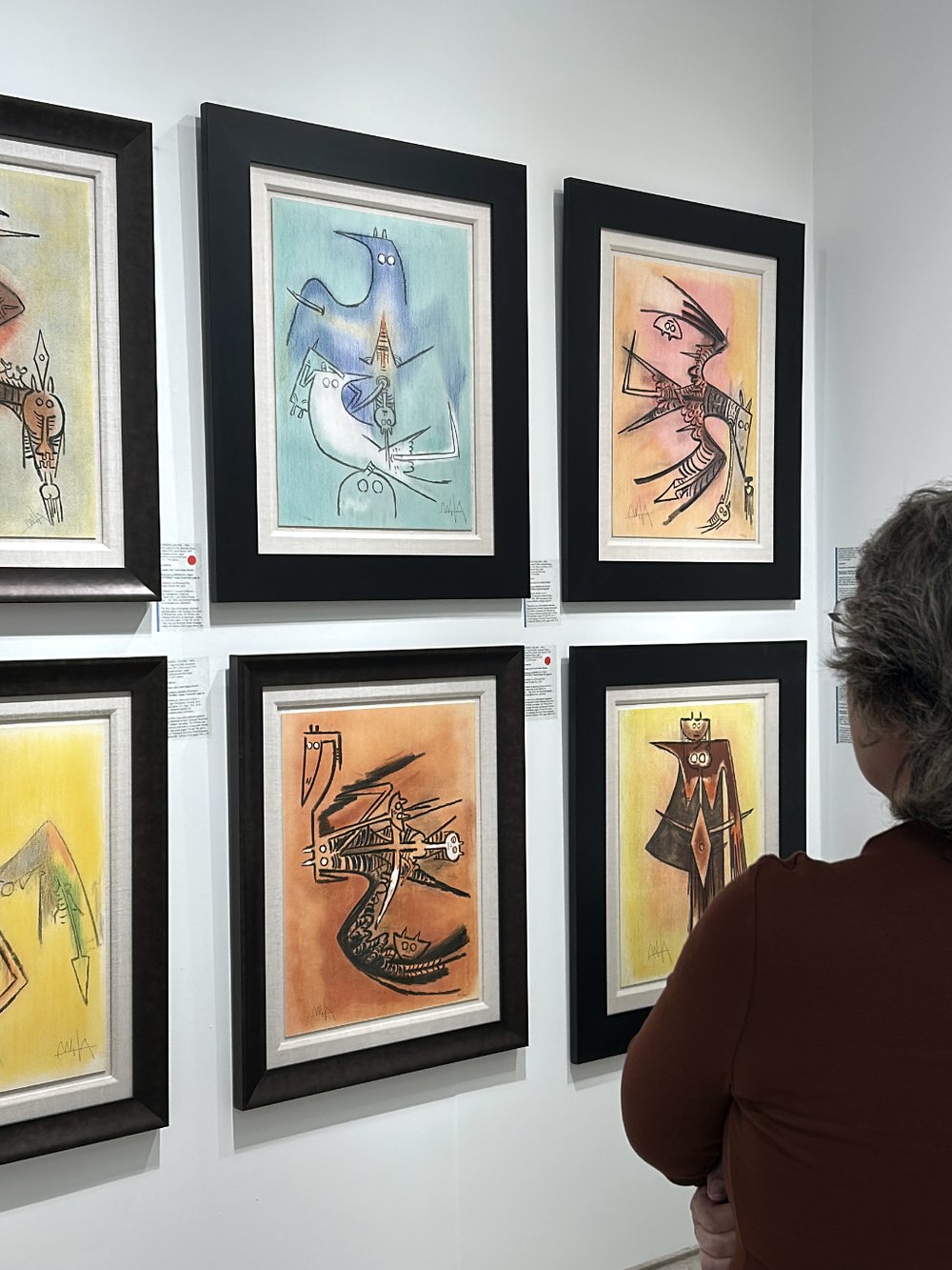 Conjunto de obra sobre papel enmarcada en una pared de feria